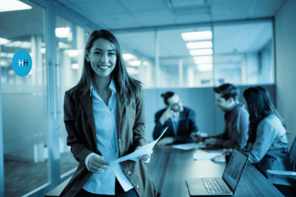 Smiling agency consultant with team behind her